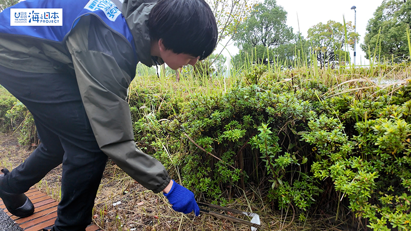 【スポGOMI】植え込みにあるごみを拾う男子高校生